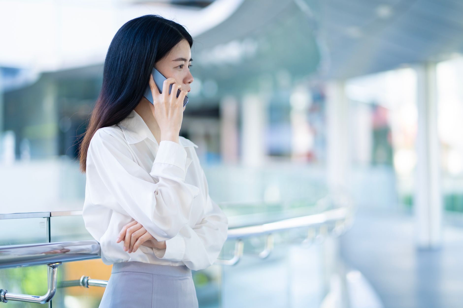 Person telefoniert vor einem modernen Bürogebäude